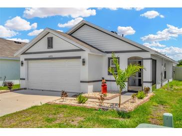 Charming single-story home featuring a two-car garage, well-maintained lawn and decorative front yard landscaping at 16892 Delia St, Wimauma, FL 33598