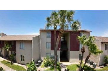 A condo building exterior shows a well-manicured lawn and palm trees at 3829 S Lake Dr # 215, Tampa, FL 33614