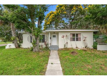 Quaint single-story home with lush landscaping, mature trees, and a welcoming entrance path on a green lawn at 4600 Chancellor Ne St, St Petersburg, FL 33703