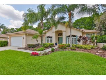 Charming single-story home boasts lush landscaping, mature palms, and a welcoming entrance at 4942 Willow Ridge Ter, Valrico, FL 33596