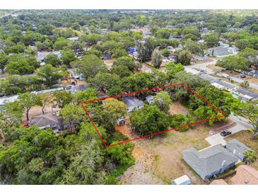 Aerial view of property with tree coverage, showing the house's lot outlined in red at 5232 72Nd N Way, St Petersburg, FL 33709