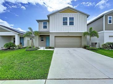 Charming two-story home with well-maintained lawn, a two-car garage, and front yard landscaping at 7554 Wallflower Trl, Wesley Chapel, FL 33545