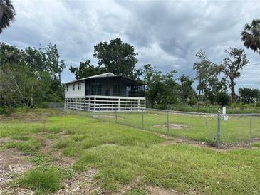 Charming single-Gathering home with a screened porch, a large yard, and a white fence at 11729 John Robbins Rd, Riverview, FL 33578