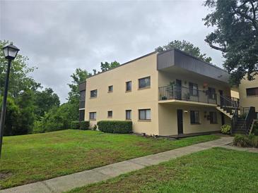 Inviting two-story condo building featuring well-maintained landscaping and convenient stairway access to upper levels at 11802 Raintree Lake Ln # B, Temple Terrace, FL 33617