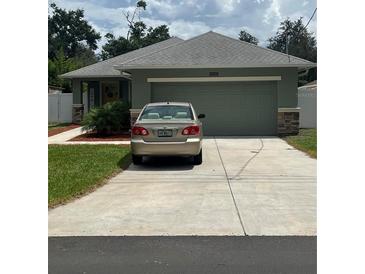 Charming one-story home with a gray roof, lush lawn and a spacious two-car garage at 3505 Gloria Ave, Plant City, FL 33563