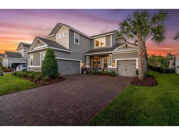 Charming two-story home with a three-car garage and a well-manicured lawn at 3850 Bonfire Dr, Odessa, FL 33556