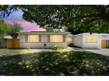 Charming home with landscaped front yard shaded by a mature tree; solar panels installed at 5010 8Th N Ave, St Petersburg, FL 33710