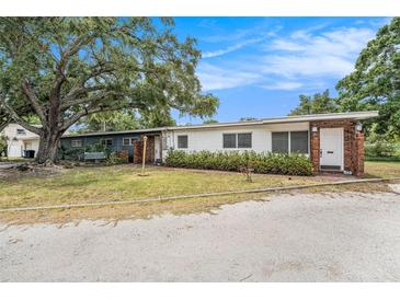 Charming single-story home featuring a brick entryway and lush landscaping, under a blue sky at 5250 12Th N St, St Petersburg, FL 33703
