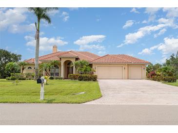 Charming Mediterranean-style home with a tile roof, three-car garage, and lush landscaping at 6120 9Th Avenue Ne Cir, Bradenton, FL 34212