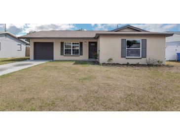 Charming single-story home with tan siding, brown shutters, and a well-maintained lawn at 717 Fairmont Dr, Brandon, FL 33511