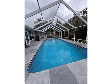Relaxing screened-in pool with stone surround, perfect for enjoying the outdoors in comfort and style at 11889 Walker Ave, Seminole, FL 33772