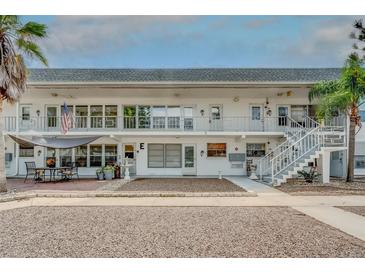 Condo exterior with stairs, landscaping, and awning-covered patio furniture offering relaxed outdoor living at 1221 Drew St # E12, Clearwater, FL 33755