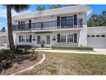 Charming condo with a balcony, manicured lawn, and a one-car garage in a tranquil neighborhood at 202 Mindy Dr, Largo, FL 33771