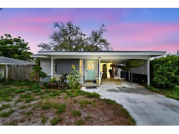 Charming home with a covered carport, front porch, and light blue door at 361 Colonial Ct, Dunedin, FL 34698