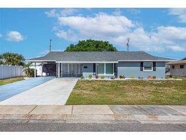 Charming single-story home with a carport, well-manicured lawn, and lovely landscaping at 906 Hacienda Dr, Sun City Center, FL 33573