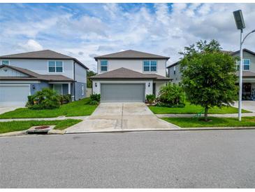 Charming two-story home with a well-manicured lawn and a two car garage at 9324 Rally Spring Loop, Wesley Chapel, FL 33545