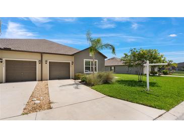 Charming home featuring a two-car garage, well-maintained lawn, and a welcoming driveway at 13423 Crest Lake Dr, Hudson, FL 34669