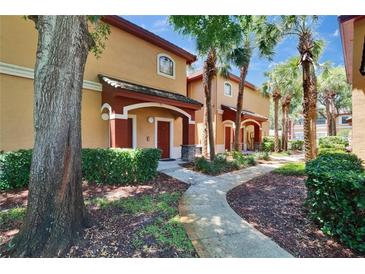 Inviting two-story townhome with landscaped walkway, mature trees, and covered entryways at 2220 Chianti Pl # 8-0828, Palm Harbor, FL 34683