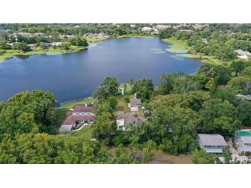 Stunning aerial view of lakefront property surrounded by lush greenery and mature trees at 2814 W Humphrey St, Tampa, FL 33614