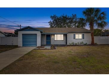 Charming single-story home with a well-maintained lawn and a quaint blue-accented garage at 416 Flamingo Dr, Apollo Beach, FL 33572