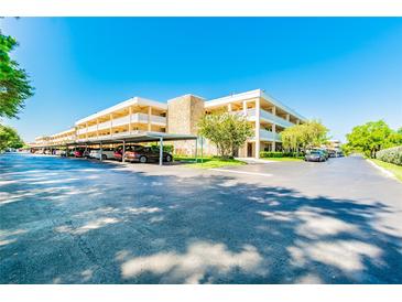 Condo complex with covered parking, mature trees, and well-maintained landscaping on a bright day at 4885 1St Ne St # 110, St Petersburg, FL 33703