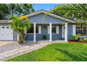 Charming home with a brick facade, white columns, and lush landscaping at 8307 Boxwood Dr, Tampa, FL 33615