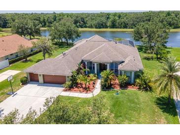 Waterfront home boasts lush landscaping, a two-car garage, and a meticulously maintained lawn at 12309 Creek Edge Dr, Riverview, FL 33579
