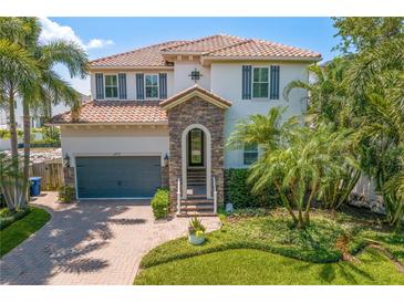 Charming two-story home featuring a tile roof, stone accents, and beautifully landscaped front yard at 4612 W Lowell Ave, Tampa, FL 33629