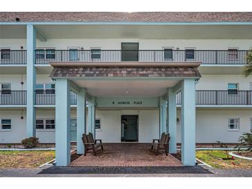 Inviting building entrance featuring a covered entryway with benches for residents and guests at 8 Glencoe Pl # 305, Dunedin, FL 34698
