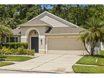 Charming single-Gathering home featuring a 2-car garage, arched entry, and well-maintained landscaping at 25332 Lexington Oaks Blvd, Wesley Chapel, FL 33544