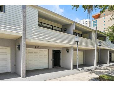 This townhome features a carport with white doors, a neutral color scheme, and a second story porch area at 301 2Nd N St # 15, St Petersburg, FL 33701