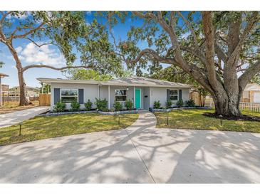 Charming single-story home with a well-manicured lawn and a vibrant turquoise front door at 526 62Nd Ne Ave, St Petersburg, FL 33702