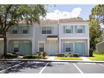 Charming townhome featuring a well-maintained exterior with colorful shutters and a lush green landscape at 8545 Hunters Key Cir, Tampa, FL 33647