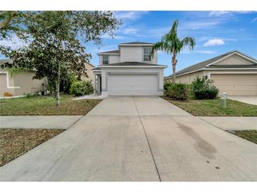 Two-story home with a two-car garage, a well-maintained lawn, and a palm tree at 1107 Seminole Sky Dr, Ruskin, FL 33570