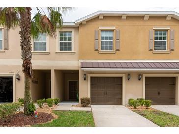 Inviting townhome featuring a well-maintained facade, attached garage, and front lawn landscaping at 11903 Greengate Dr, Hudson, FL 34669