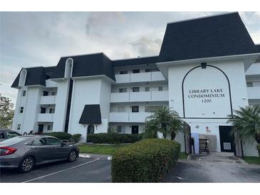 Library Lake Condominiums featuring white facade, black roofs, well-maintained landscaping and ample parking at 1200 37Th N St # 403, St Petersburg, FL 33713