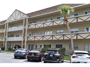 A low-rise multi-Gathering condominium building with a beautiful palm tree, and parking at 2463 Brazilia Dr # 43, Clearwater, FL 33763