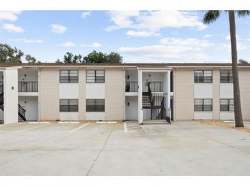 Apartment building exterior featuring multi-level access, parking, and neutral color scheme at 3102 W Horatio St # 13, Tampa, FL 33609