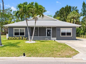Charming single-story home with a well-maintained lawn, palm trees, and gray exterior at 366 12Th Ave, Indian Rocks Beach, FL 33785