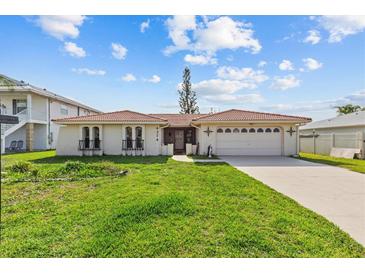 Charming single-story home with a red tile roof, a well-maintained lawn, and an attached two-car garage at 4274 Deleon Dr, Hernando Beach, FL 34607