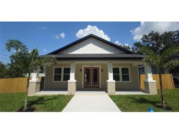 Charming single-story home with craftsman details, a welcoming porch, and a well-manicured lawn at 7013 N 15Th St, Tampa, FL 33610