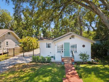 Charming home featuring a lovely brick pathway and a welcoming blue front door at 106 W Louisiana Ave, Tampa, FL 33603