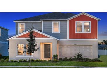 Charming two-story home with a gray and orange exterior, and a well-manicured lawn at 13040 Wellspring Dr, Lithia, FL 33547