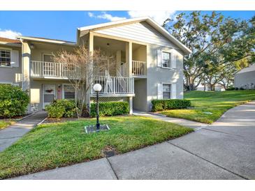Charming condo showcasing well-maintained landscaping and a welcoming front entrance with dual balconies at 1390 Oak Hill Dr # 206, Dunedin, FL 34698
