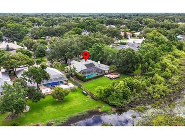 Beautifully landscaped property featuring pool, enclosed patio, and fenced yard at 16804 Windsor Park Dr, Lutz, FL 33549