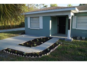 Charming single-story home with a well-manicured front yard and a quaint flower bed leading to the entrance at 3421 E Powhatan Ave, Tampa, FL 33610