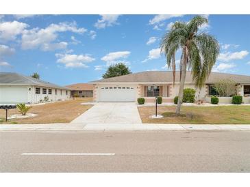 Charming single-story home featuring a well-manicured lawn and a spacious two-car garage at 406 S Pebble Beach Blvd, Sun City Center, FL 33573