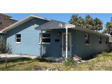 A single-story home with a blue exterior, featuring a covered front porch and a well-maintained yard at 844 Bruce Ave, Clearwater Beach, FL 33767