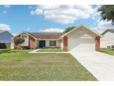 Charming single-story home with brick accents, a blue front door, and a well-maintained lawn under a bright, partly cloudy sky at 1421 Buckner Rd, Valrico, FL 33596