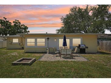 Backyard featuring a cozy patio with a grill, table, and fire pit, perfect for outdoor entertaining at 1450 Seabreeze St, Clearwater, FL 33756